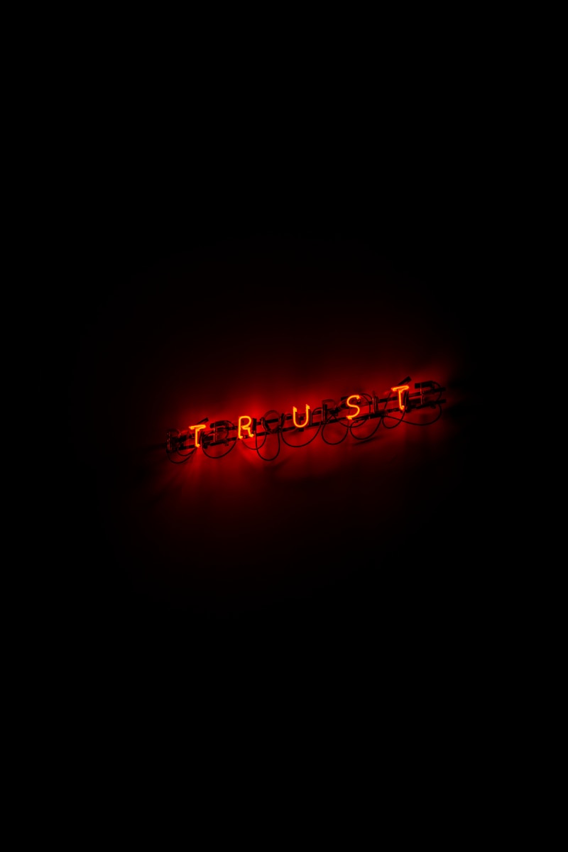 A red trust sign lit up in the dark